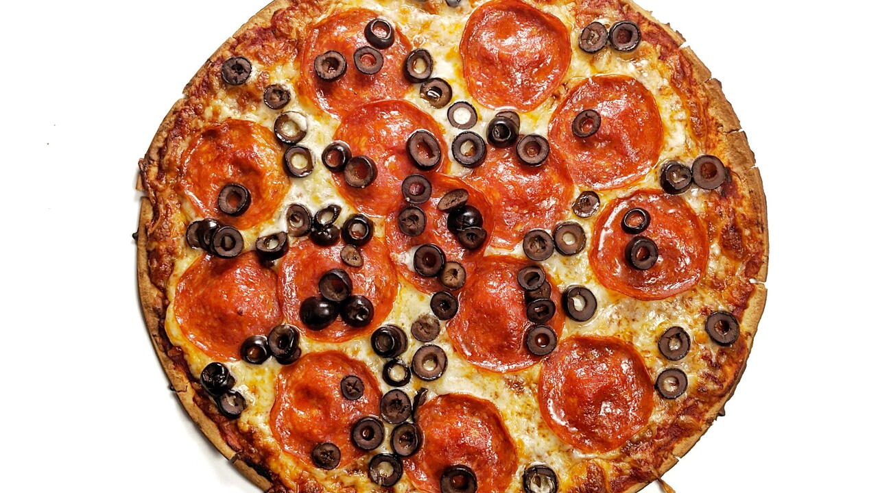 A pizza with pepperoni and black olives.