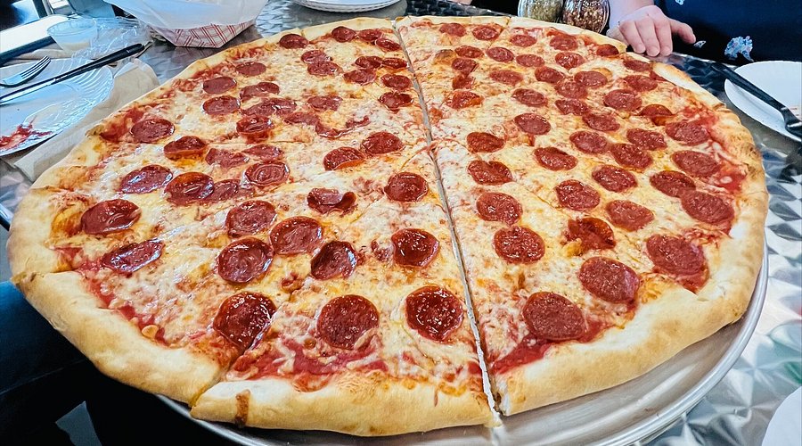 A giant, pepperoni pizza on a dinner table.